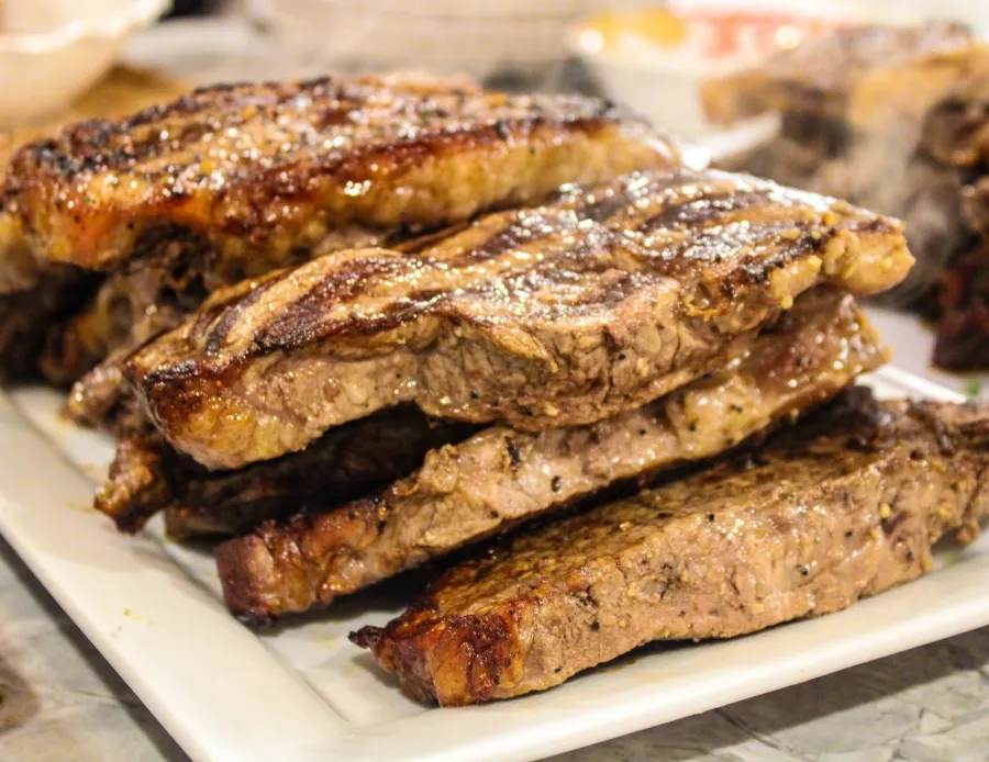 Close-up of stacked grilled steaks with char marks